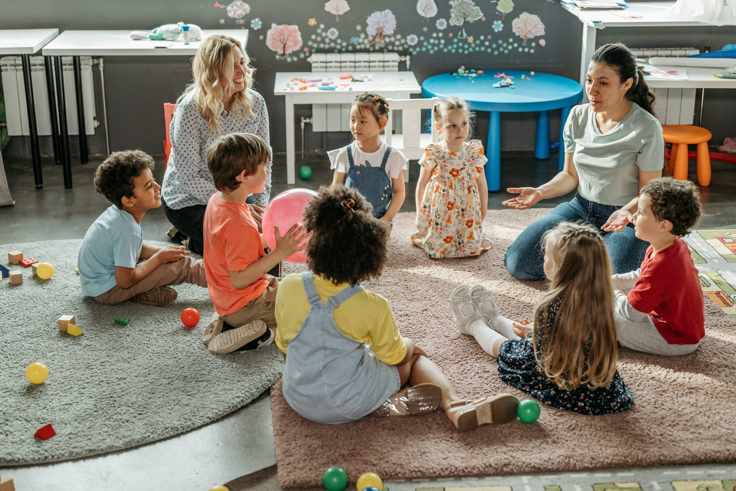 Deux professionnelles de petite enfance avec un petit groupe d'enfants