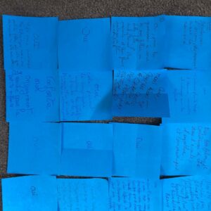 Post-it bleus affichés sur un sol, avec des messages écrits à la main en faveur du soutien à la parentalité.