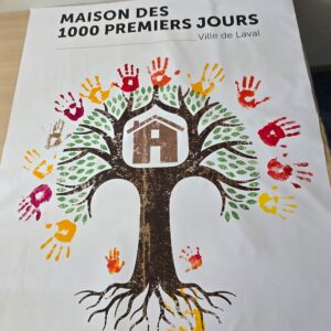 Toile des 1000 premiers jours avec un arbre au centre, dans l'arbre il y a une maison. Autour de l'arbre il y a les mains en peinture de chacun des participants à l'inauguration.